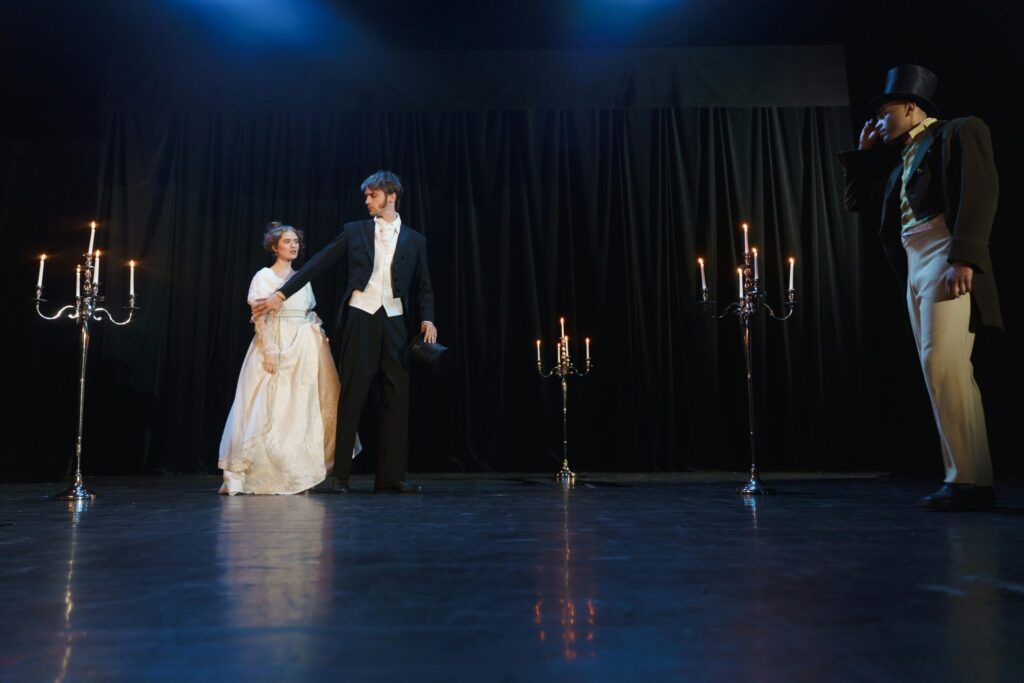 two men and a woman acting on stage