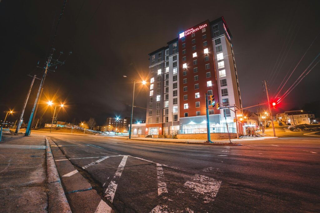 roadway near modern building and glowing street lights at night
