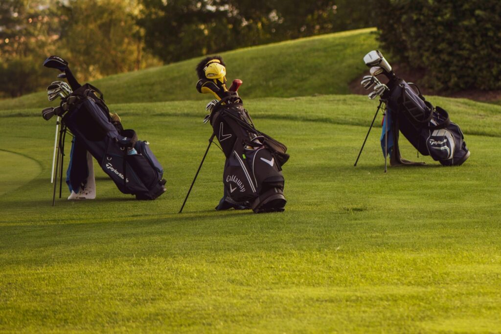 three bags with golf clubs inside